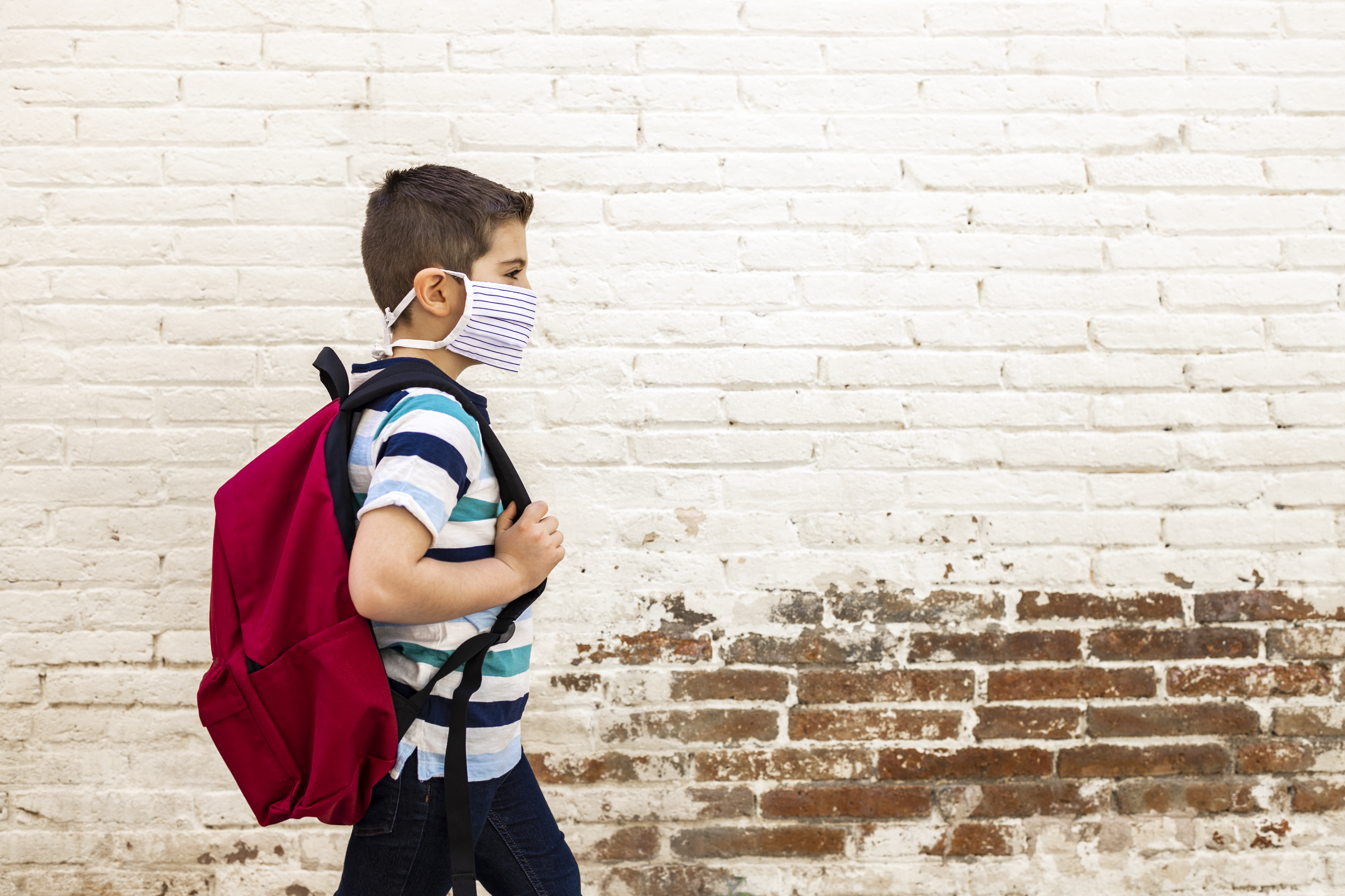 boy with backpack wearing mask